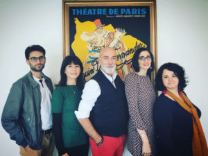 Photo de l'équipe de la mission posant devant une vieille affiche du Théâtre de Paris
